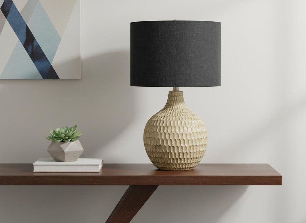 25" Brown Geometric Table Lamp With Black Drum Shade displayed on a tabletop in a furnished interior against an off-white wall.