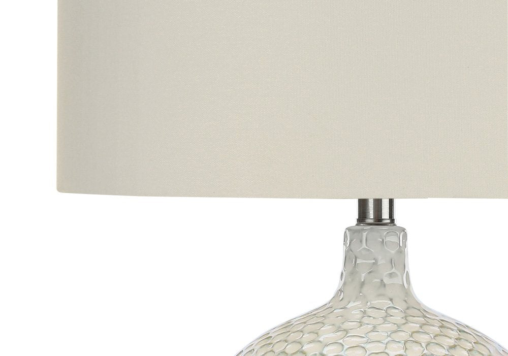 28" White and Silver Ceramic Round Table Lamp With Cream Drum Shade. Table lamp isolated on a plain white background, showing a cream ceramic surface.