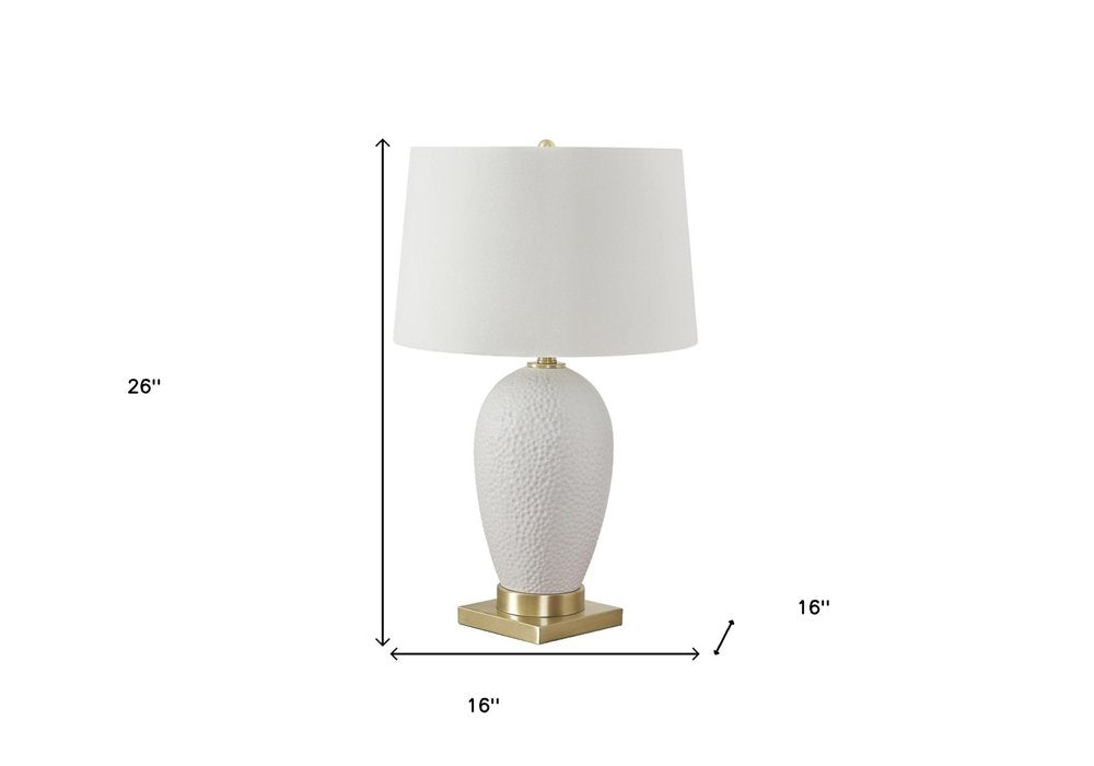 26" Gold and White Ceramic Urn Table Lamp With Cream Empire Shade. Table lamp isolated on a plain white background, showing a cream ceramic surface.