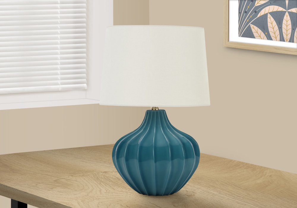 24" Blue Ceramic Gourd Table Lamp With Cream Empire Shade displayed on a wood tabletop in a furnished interior against an off-white wall.