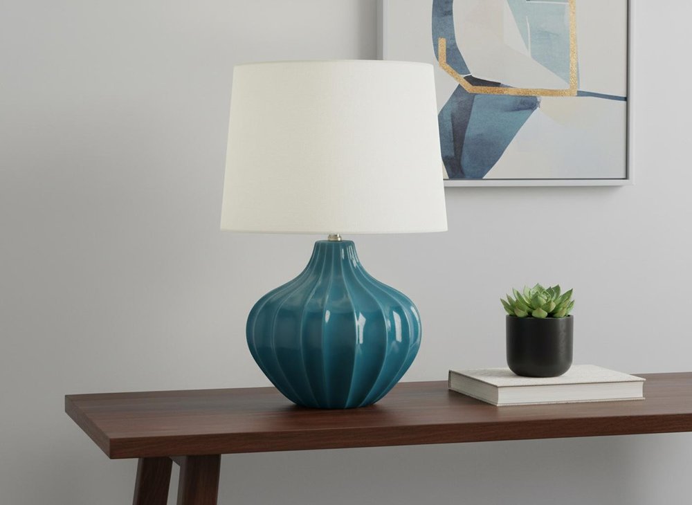24" Blue Ceramic Gourd Table Lamp With Cream Empire Shade displayed on a tabletop in a furnished interior against a light gray wall.