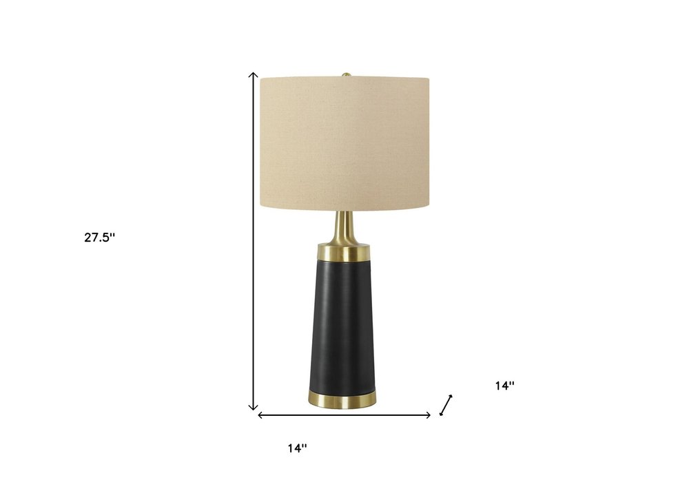 28" Black and Gold Metal Cylinder Table Lamp With Beige Drum Shade. Table lamp isolated on a plain white background, showing a beige metal surface.
