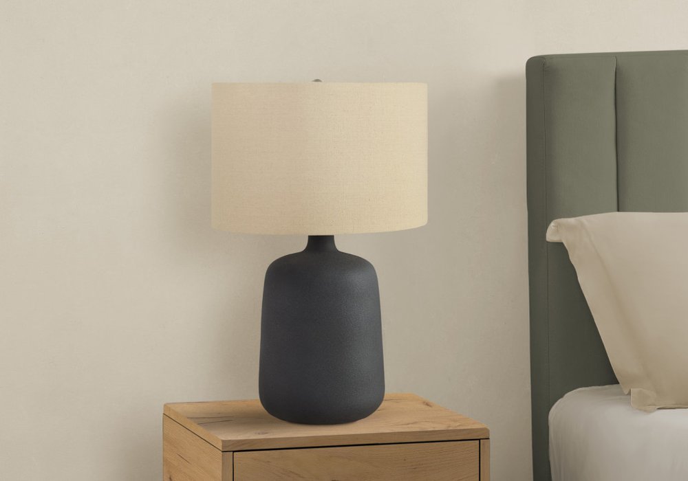 Detail view of 24" Black Ceramic Round Table Lamp With Beige Drum Shade, filling the frame with the beige ceramic texture.