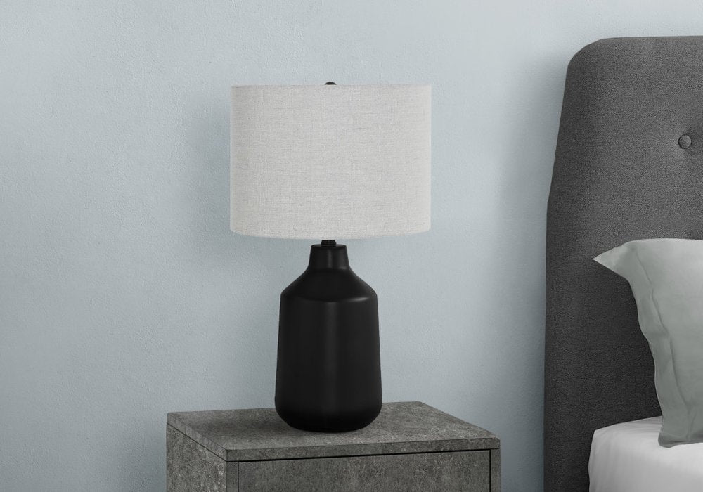 24" Black Concrete Urn Table Lamp With Gray Drum Shade. Table lamp isolated on a plain white background, in a black finish.