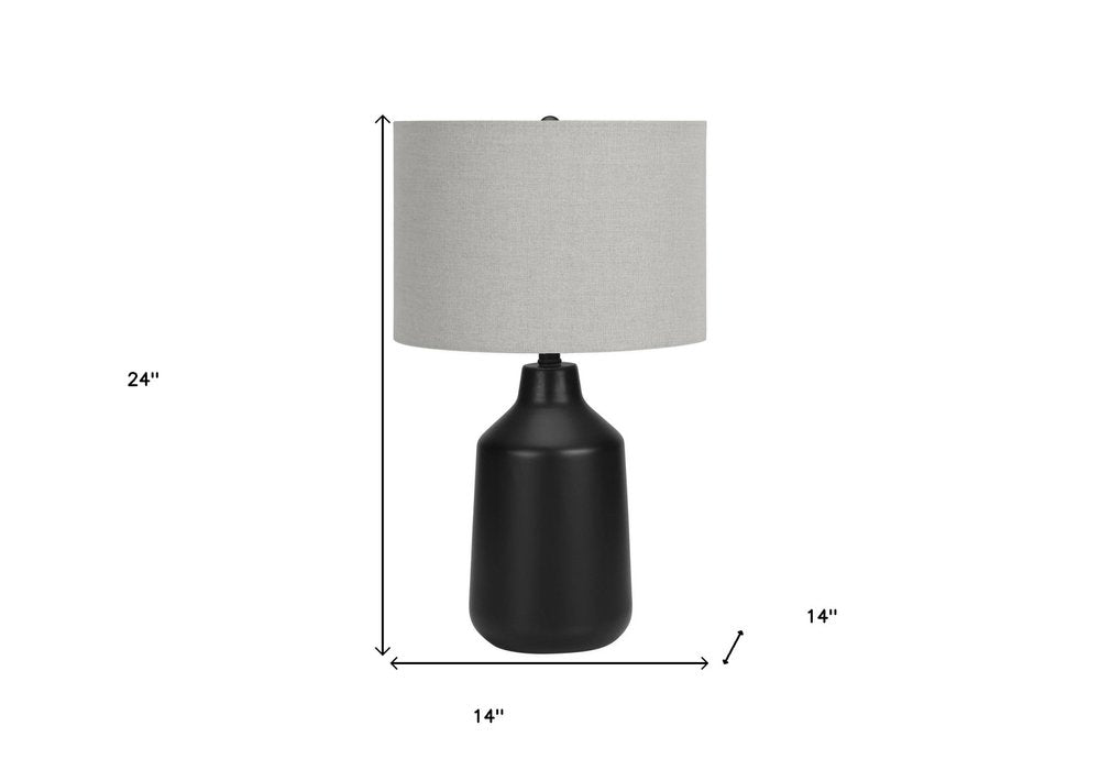 24" Black Concrete Urn Table Lamp With Gray Drum Shade. Table lamp isolated on a plain white background, finished in black.