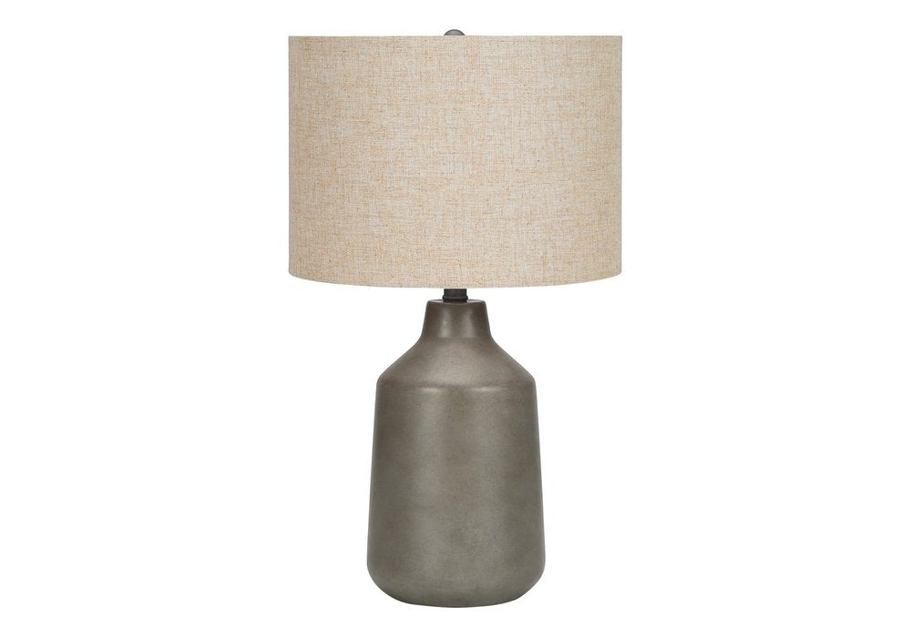 24" Gray Concrete Urn Table Lamp With Beige Drum Shade. Table lamp isolated on a plain white background, finished in beige.