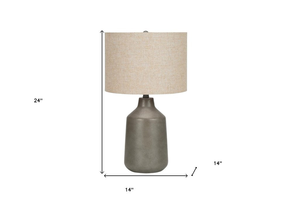 24" Gray Concrete Urn Table Lamp With Beige Drum Shade. Table lamp isolated on a plain white background, in a beige finish.