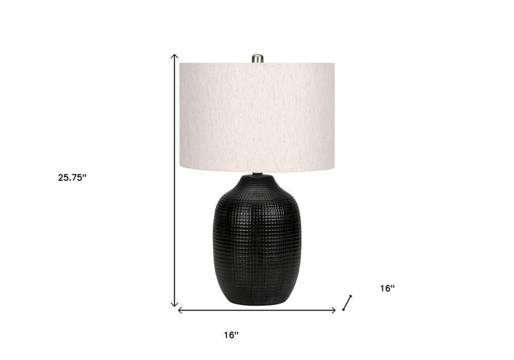 26" Black Ceramic Urn Table Lamp With Ivory Drum Shade. Table lamp isolated on a plain white background, showing a ivory ceramic surface.