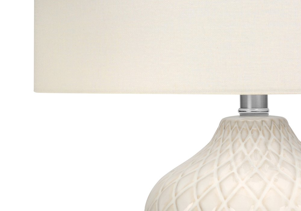 25" Cream Ceramic Urn Table Lamp With Cream Drum Shade. Table lamp isolated on a plain white background, showing a cream ceramic surface.