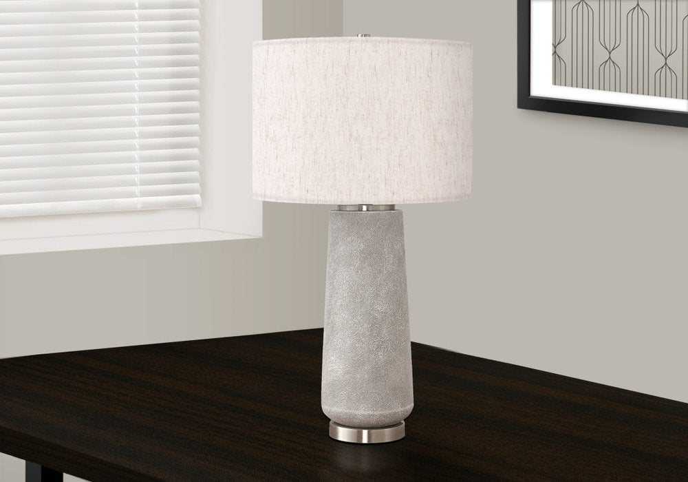 29" Gray and Silver Cylinder Table Lamp With Ivory Drum Shade photographed against a dark studio background in ivory.