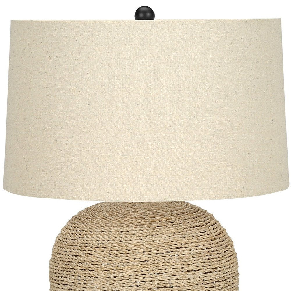 25" Beige Rattan Round Table Lamp With Beige Drum Shade. Table lamp isolated on a plain white background, finished in beige rattan.