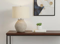 25" Cream Concrete Round Table Lamp With Beige Drum Shade. Table lamp isolated on a plain white background, finished in cream.