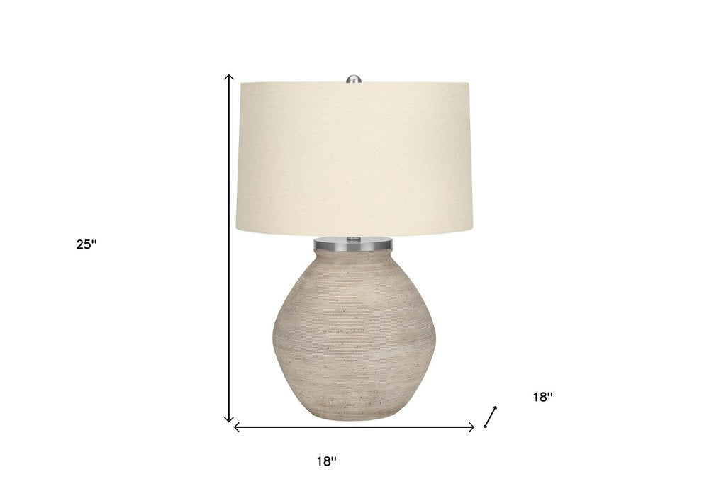25" Cream Concrete Round Table Lamp With Beige Drum Shade. Table lamp isolated on a plain white background, finished in cream.