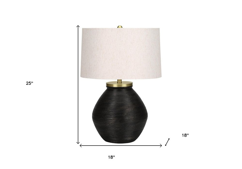 25" Black and Gold Concrete Round Table Lamp With Ivory Drum Shade. Table lamp isolated on a plain white background, showing its ivory color.