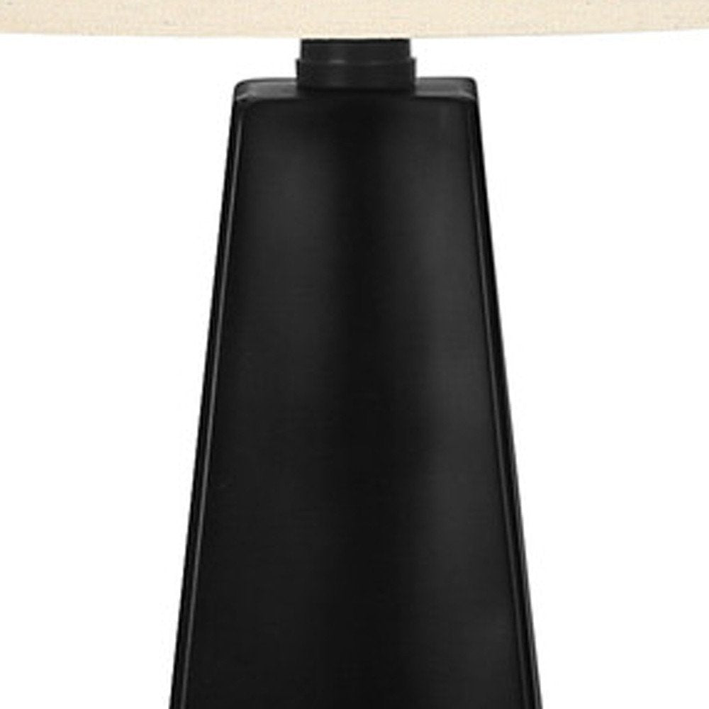 27" Black Geometric Table Lamp With Beige Drum Shade. Table lamp isolated on a plain white background, in a beige finish.
