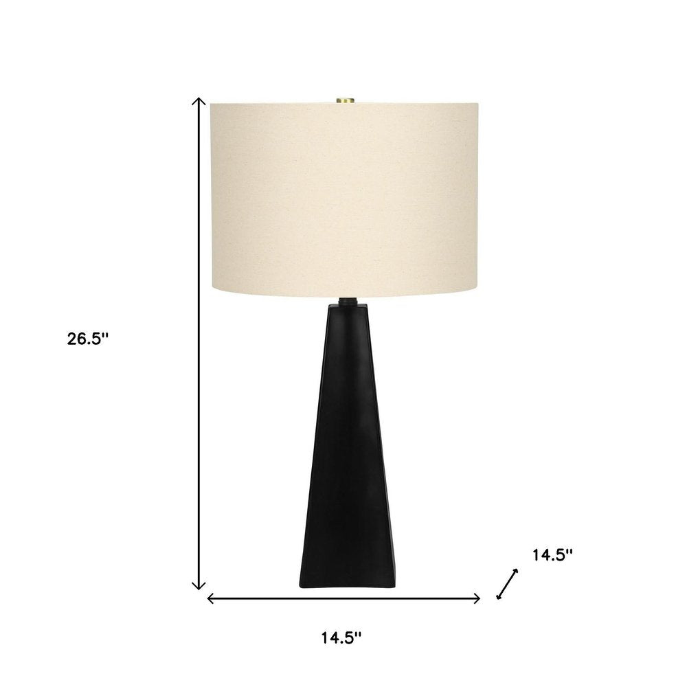 27" Black Geometric Table Lamp With Beige Drum Shade. Table lamp isolated on a plain white background, finished in beige.