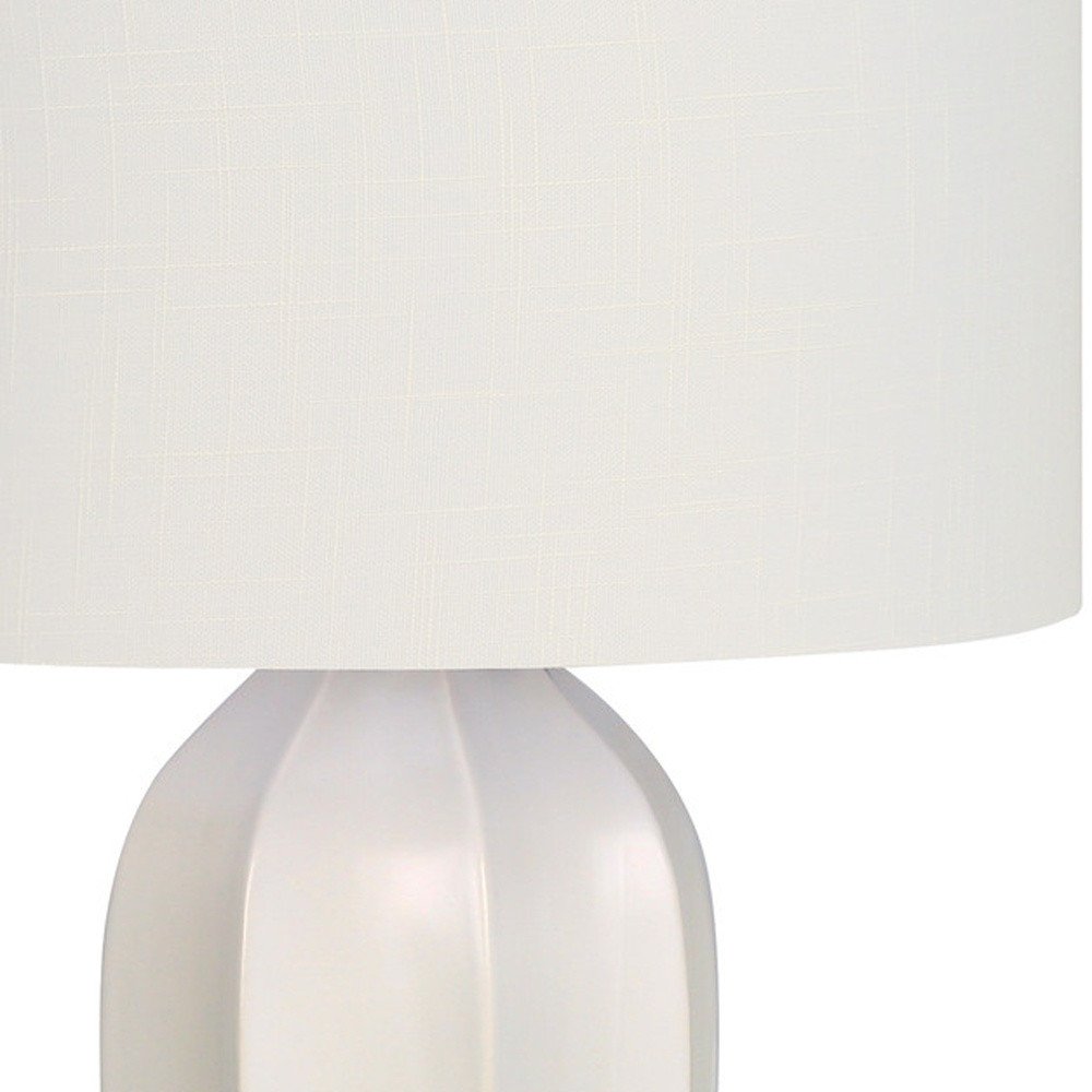 27" Cream Ceramic Geometric Table Lamp With Cream Drum Shade. Table lamp isolated on a plain white background, showing a cream ceramic surface.