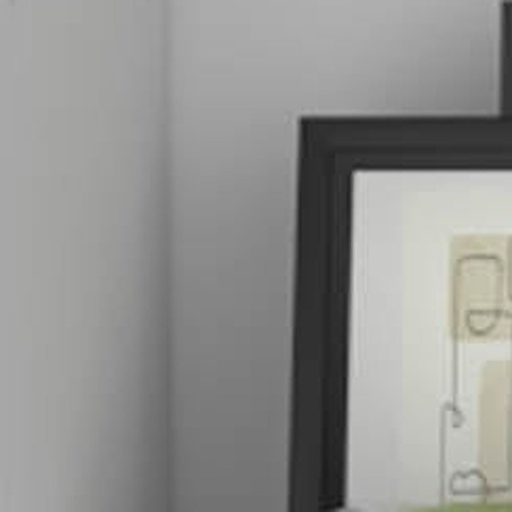 Framed artwork with abstract shapes and lines on a white background, set against a gray wall.