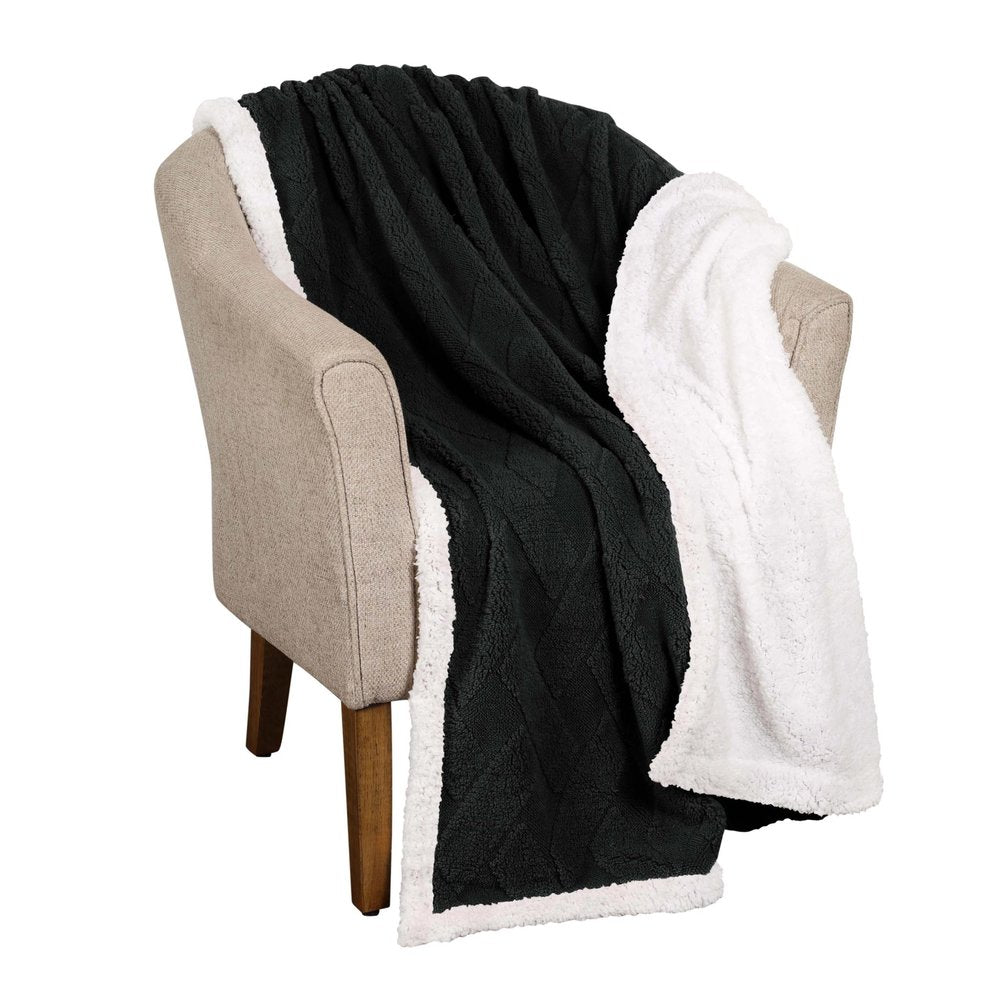 Black and white plush knit throw blanket draped over a beige armchair.