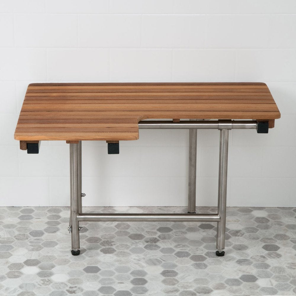 Brown teak wood shower bench with stainless steel legs, mounted on a white tiled wall and grey hexagonal tiled floor.