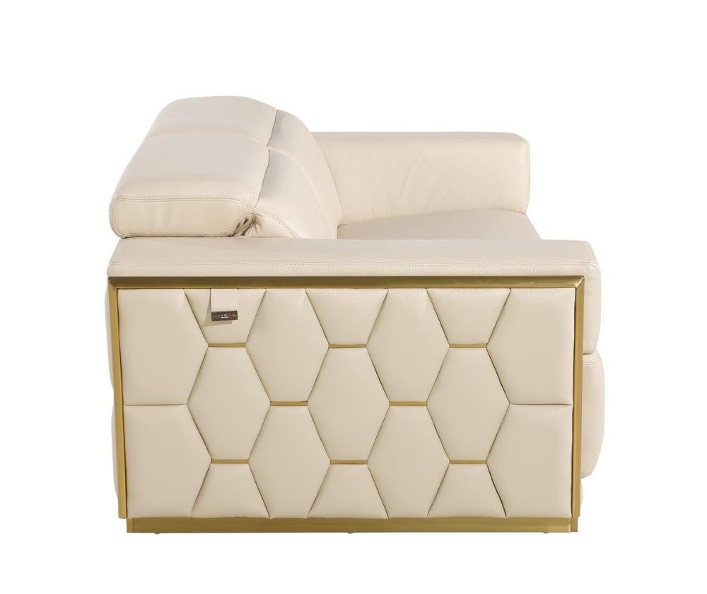 Side view of a white leather sofa with gold accents and a hexagonal pattern on the base, on a white background.