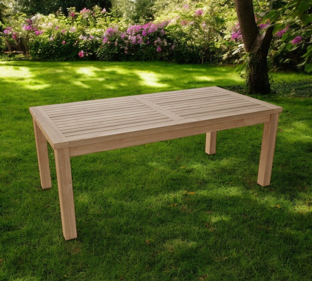 47" Natural Solid Wood Outdoor Coffee Table - 16" H x 47" W x 23" D shown outdoors on a patio with greenery in tan wood.