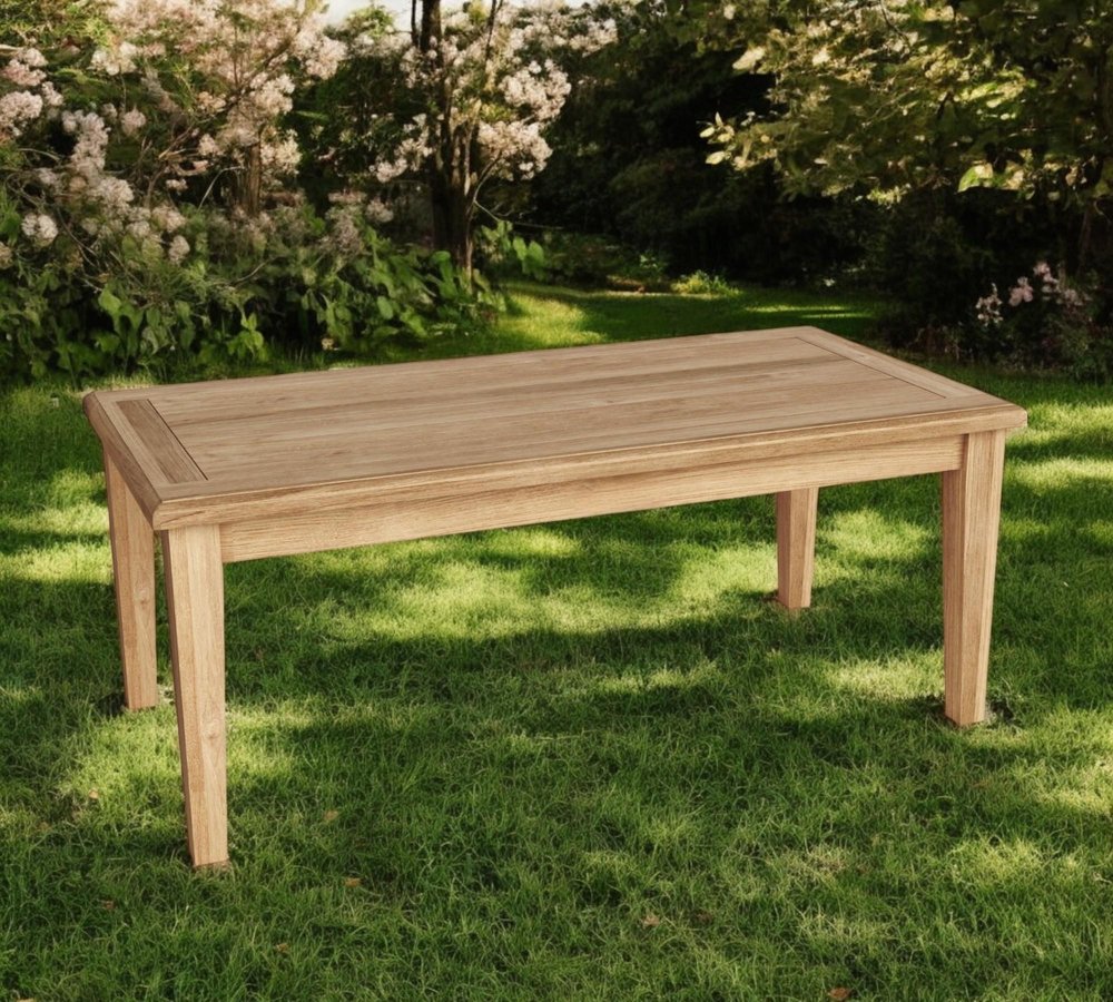 47" Natural Solid Wood Outdoor Coffee Table - 19" H x 47" W x 23" D shown outdoors on a patio with greenery in tan wood.
