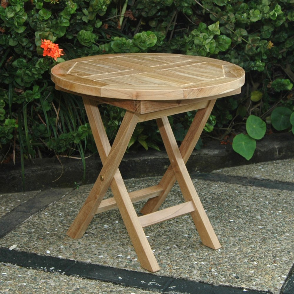 20" Natural Rounded Solid Wood Folding Outdoor Side Table - SKU 554935 shown outdoors on a patio with greenery.