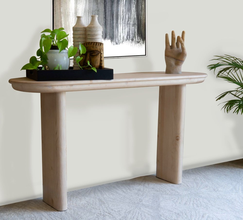 60" Natural Solid Wood Oval Console Table styled in a furnished interior with an off-white wall on a blue floor.