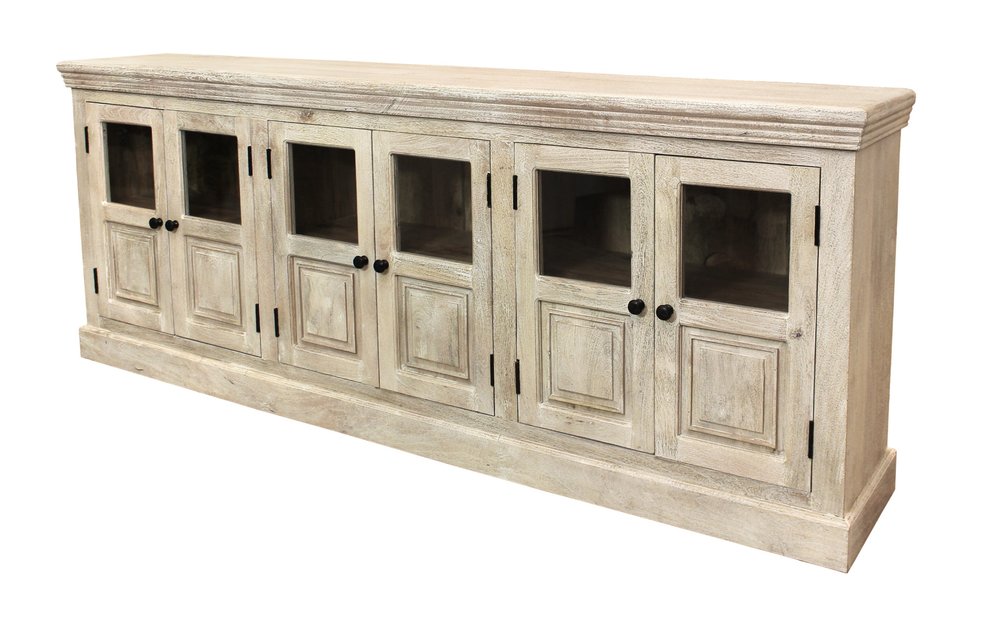 A long, antiqued white distressed solid wood sideboard with six glass doors and black knobs on a white background.