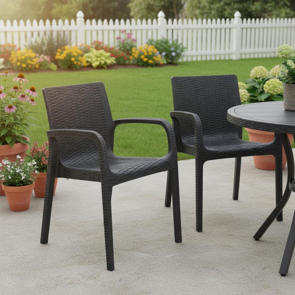 Set of Two Black Faux Rattan Heavy Duty Plastic Outdoor Stacking Arm Chairs in a home interior