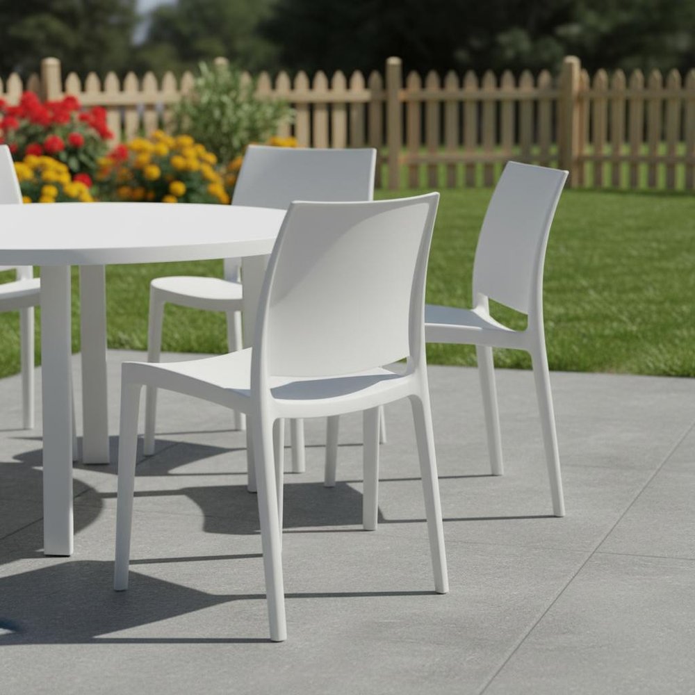 Set of Four White Heavy Duty Plastic Outdoor Stacking Dining Chairs in a home interior