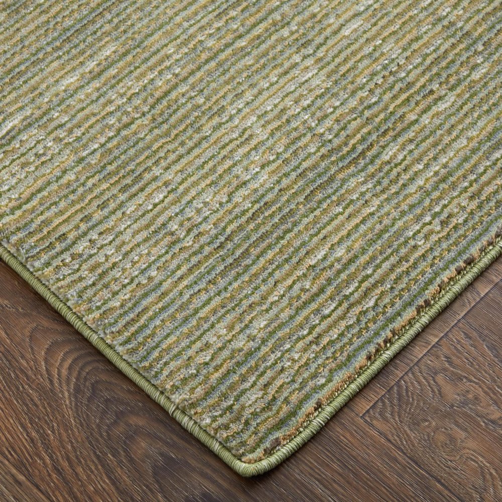 9' X 13' Tan and Green Power Loom Area Rug in a home interior