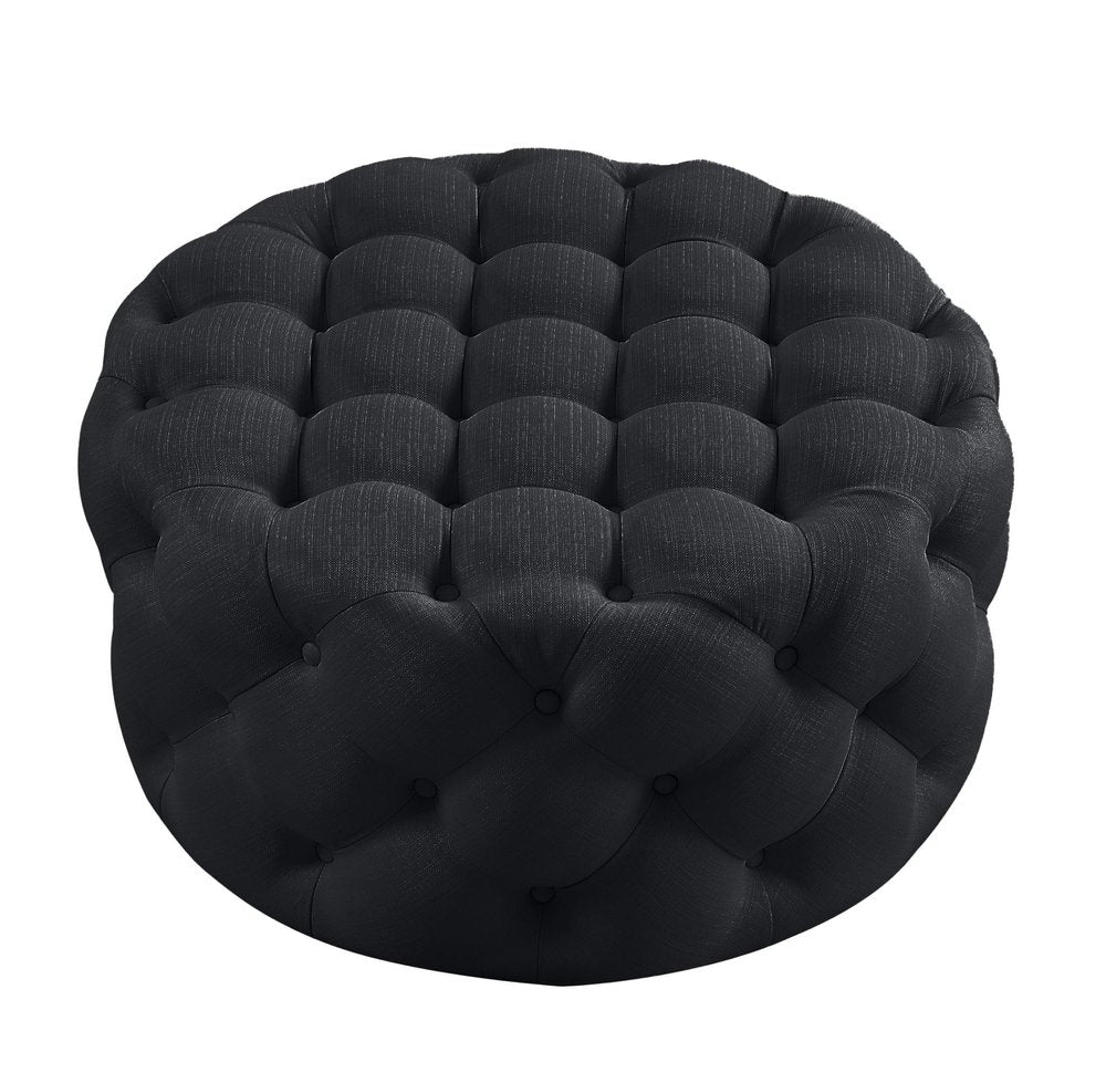 33" Black Linen Tufted Round Cocktail Ottoman. Ottoman isolated on a plain white background, in a black linen finish.