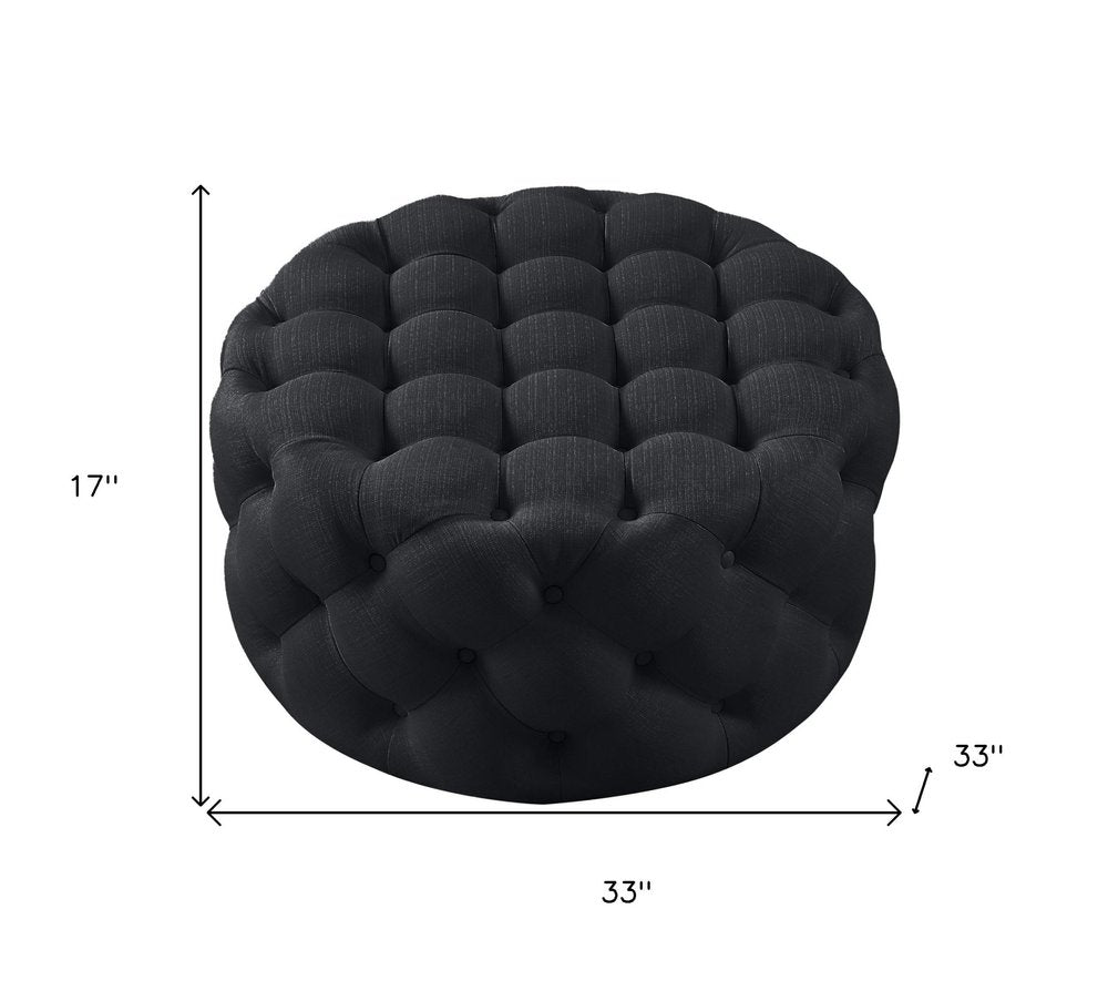 33" Black Linen Tufted Round Cocktail Ottoman. Ottoman isolated on a plain white background, finished in black linen.