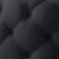 33" Black Linen Tufted Round Cocktail Ottoman photographed against a dark studio background in black.