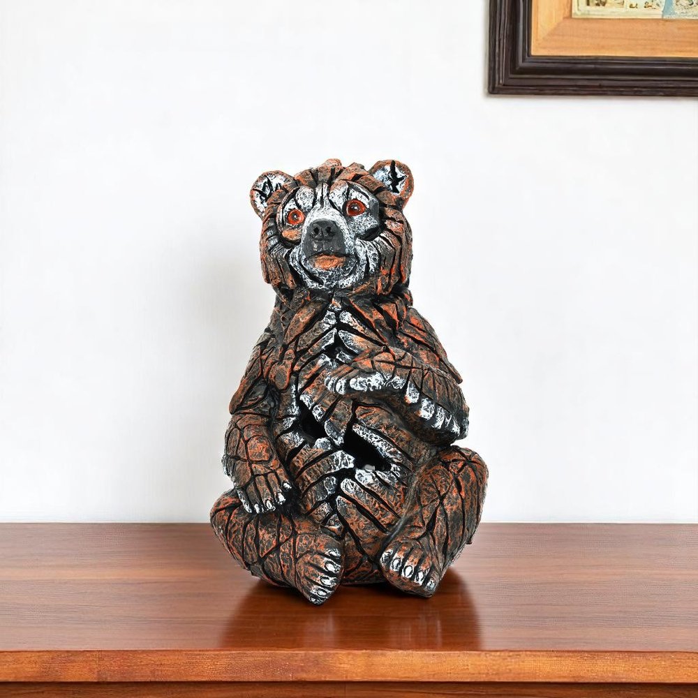 6" Brown White And Black Resin Bear Tabletop Sculpture. Sculpture isolated on a plain white background, showing a black resin surface.