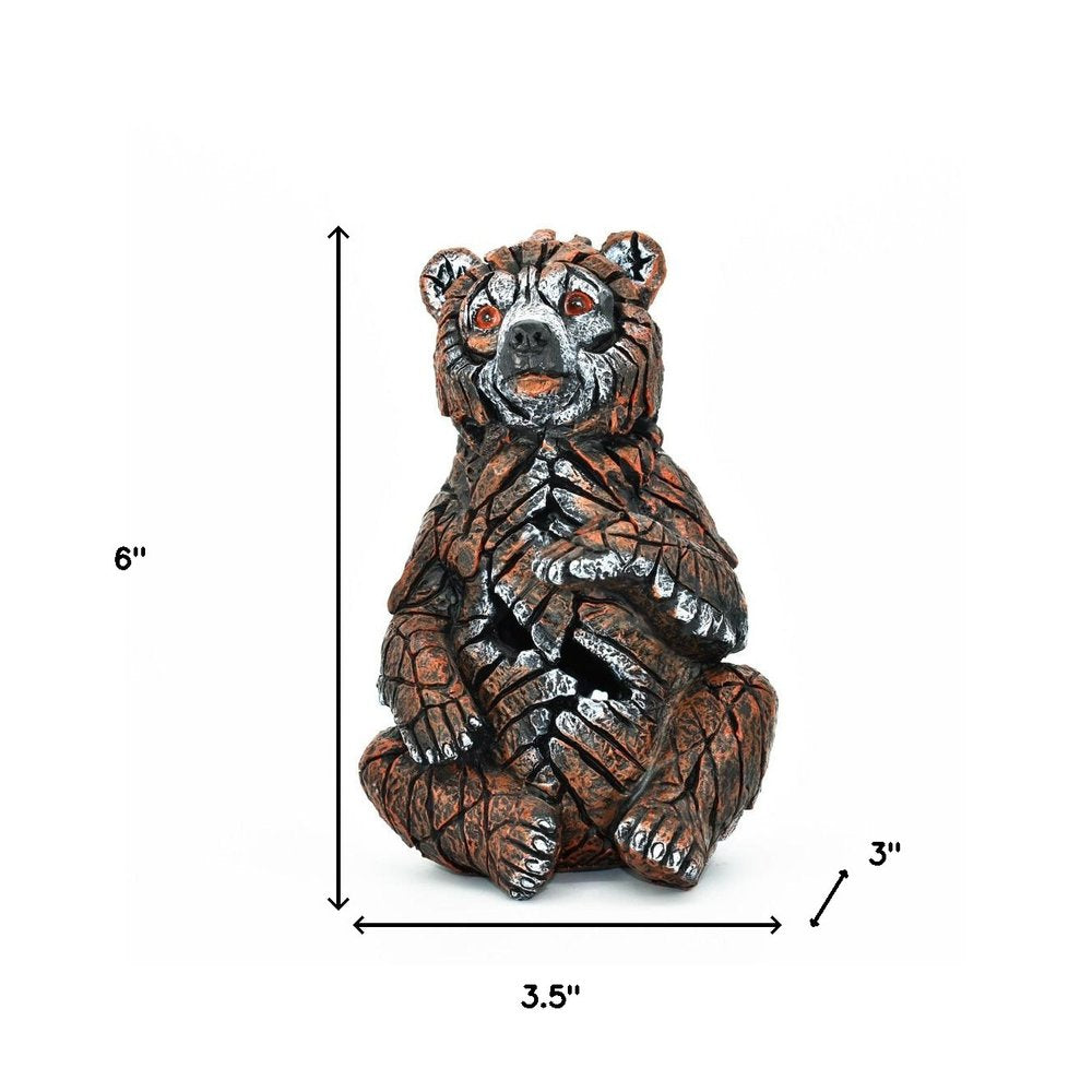 6" Brown White And Black Resin Bear Tabletop Sculpture. Sculpture isolated on a plain white background, showing a black resin surface.