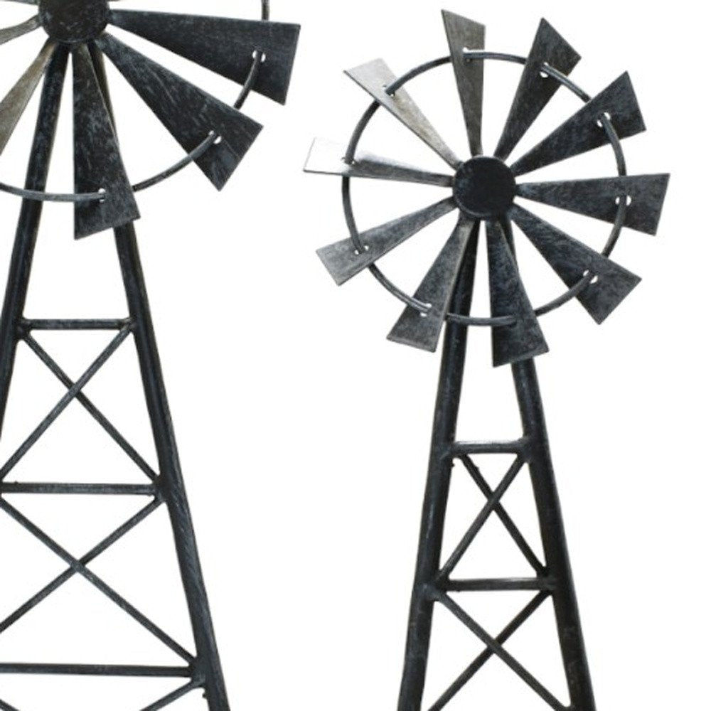 Set of two pewter metal windmill tabletop sculptures against a white background.