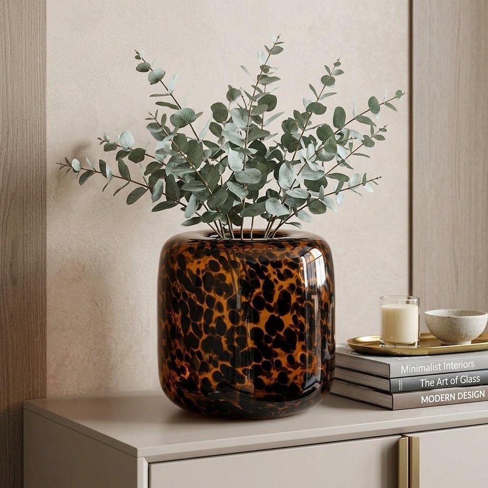 8" Amber And Black Animal Print Glass Round Table Vase in a home interior