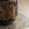 8" Amber And Black Animal Print Glass Round Table Vase in a home interior