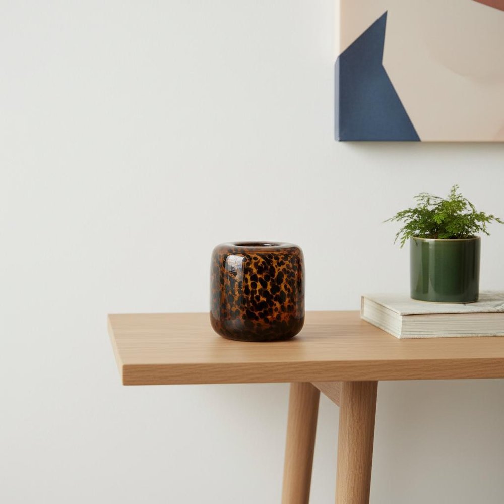 8" Amber And Black Animal Print Glass Round Table Vase in a home interior