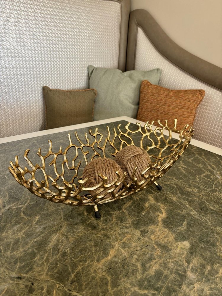 22" Silver Aluminum Faux Coral Oval Centerpiece Bowl styled in a furnished interior with a tan wall on a wood floor.