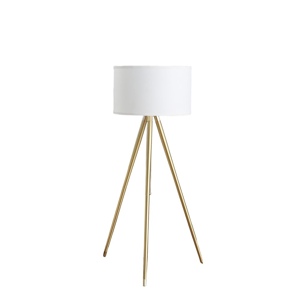 Gold metal tripod floor lamp with a white linen drum shade against a white background.