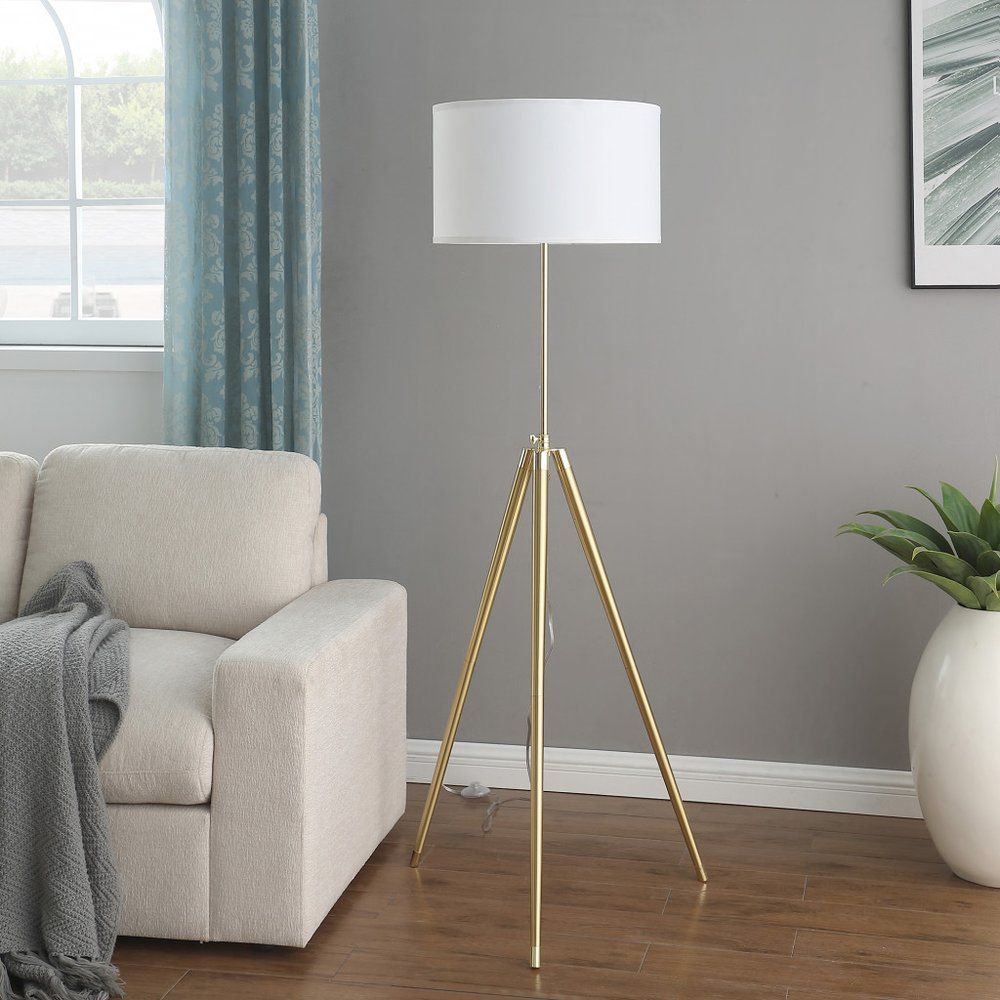 Gold Metal Adjustable Tripod Floor Lamp With White Linen Drum Shade in a home interior