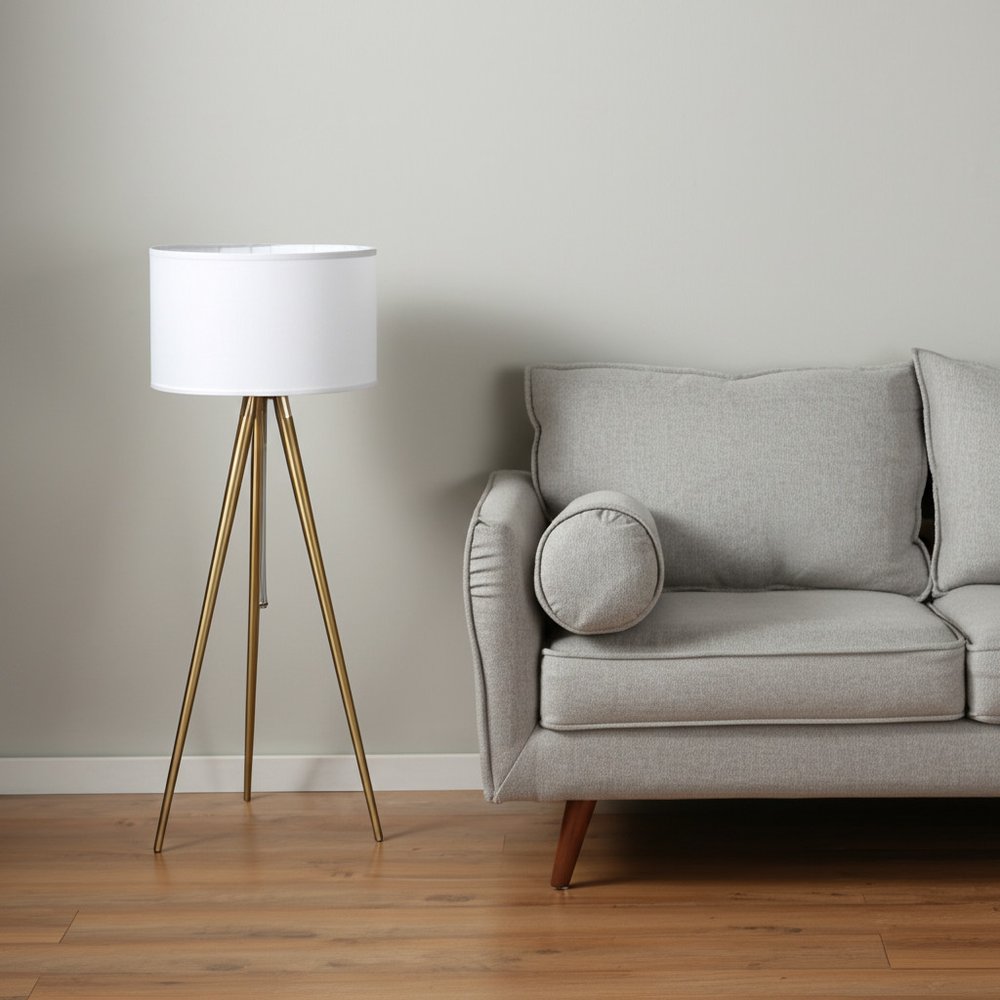 Gold Metal Adjustable Tripod Floor Lamp With White Linen Drum Shade in a home interior