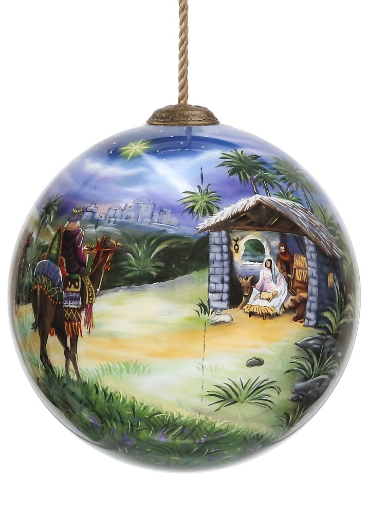 Hand-painted glass ball ornament depicting the Nativity scene with the Three Kings on a camel, set against a starry night sky and a stable.