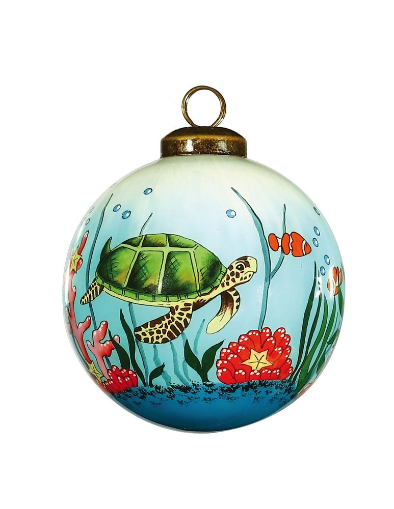 Glass ball ornament with a hand-painted sea turtle, clownfish, and coral reef scene in green, red, and blue.