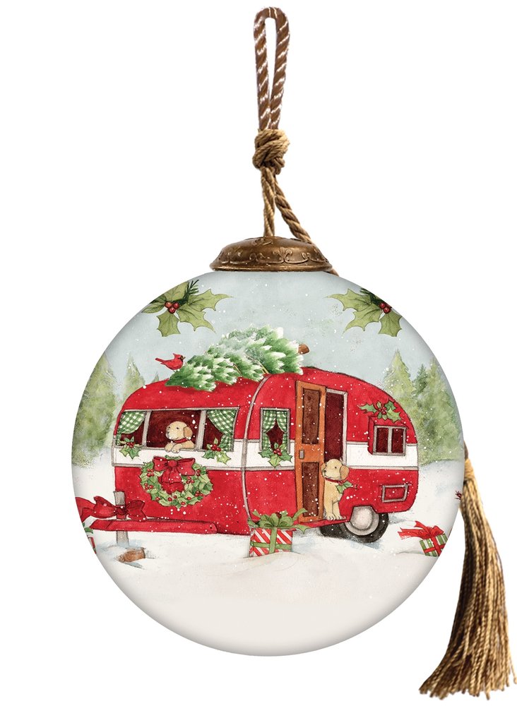 Red and white glass ball ornament with a Christmas scene of a camper, dogs, and presents, with a tassel and rope hanger.
