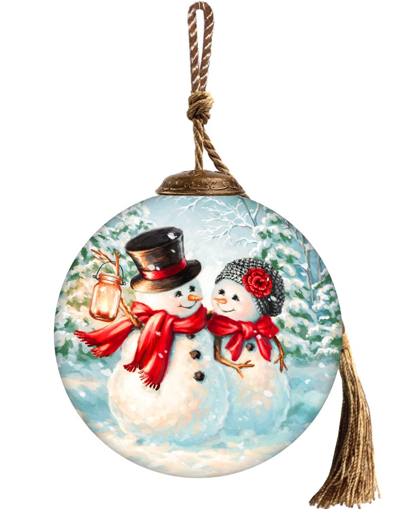 Round glass Christmas ornament with hand-painted snowmen in a winter scene, featuring red scarves and a lantern.